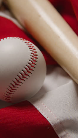 Vertical-Video-Overhead-Baseball-Still-Life-With-Bat-Ball-And-Catchers-Mitt-On-American-Flag